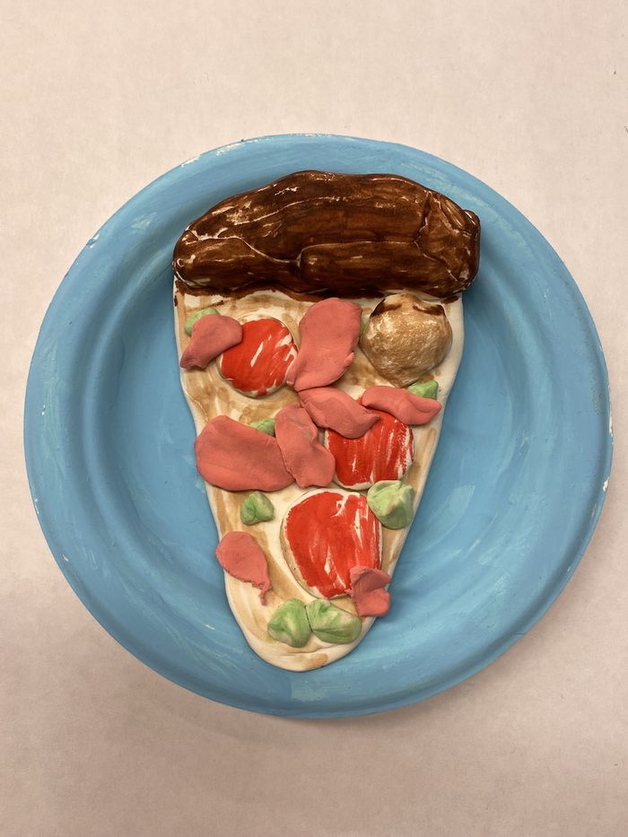 A top down view of a sculpted pizza slice made of air dry clay