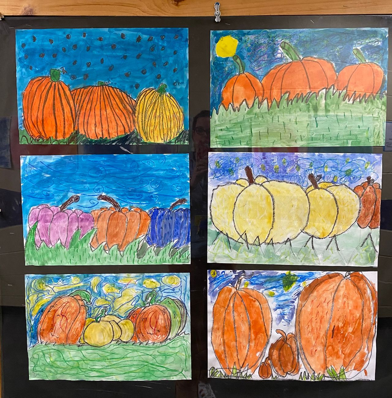 A series of 6 drawings by young artists, each one depicting pumpkins in a patch in front of a starry night. Inspired by Van Gough.